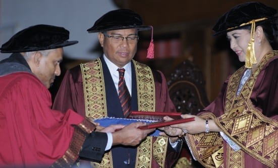 HRH Raja Zarith Sofia (right) handing scroll to one of the graduates at UTM 52nd Convocation Ceremony