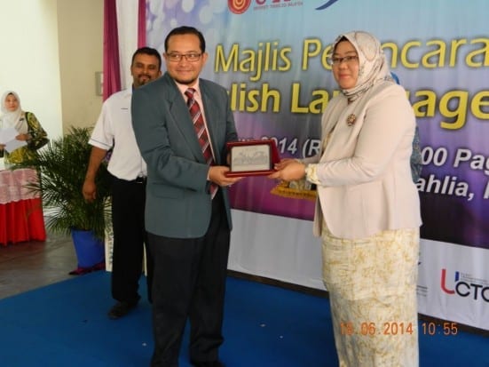 Assoc. Prof. Dr. Nur Naha (right) handing souvenirs to Hermee Tahir on the launching ceremony of UTM English Enrichment Program at SK Taman Bukit Dahlia, Pasir Gudang.