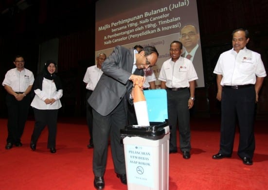 Prof.Wahid putting the replica of giant cigarette into the dustbin as symbol of campaign against smoking in UTM compound.