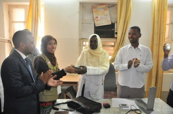 Nadhirah presenting cash to Dr Huda.