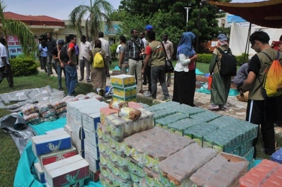 Students looking at lour, sugar, milk, oat and rice and canvas they bought for flood victims.