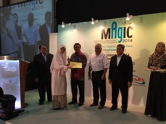 Prof. Wan Azlina receiving the ‘All Cosmo Green Technology Award’ mock cheque worth RM1000.00 with Gold Medal at the MAGIC 2014 prize giving ceremony held at MAEPS, Serdang.