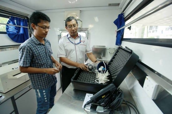 Prof. Razman (right) and one of his post-graduates students showing one of the water analysis tools available on board of UTM Mobile Laboratory. 