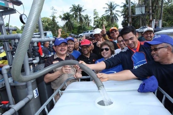 From left, Dr Ewon Ebin, Prof. Wahid Omar and Dr. Sheikh Muszaphar (holding the pipe) at the launching ceremony of UTM Portable Water Filter Machine at Pekan, Pahang.