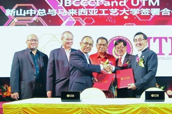 Prof Wahid Omar (three left) exchanging documents with Loh Liam Hiang, JBCCCI President witnessed by Khaled Nordin (red shirt) at PERSADA Johor.