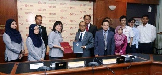 Catherine Ridu (fourth left) exhancing document with Prof. Wahid Omar after the signing ceremony between UTM and SEDA located at Main Meeting Room, Sultan Ibrahim Chancellery Building.