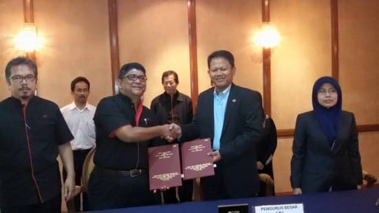 Prof. Hamdan (dua kiri) bertukar dokumen perjanjian dengan Muhammad Razif selepas majlis menandatangani Memorandum Persafahaman di Bilik Canselor, Dewan Sultan Iskandar, UTM Johor Bahru.
