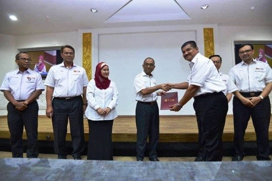 Prof. Wahid giving the certificate of appointment as UTM Security Director to Abd Rahim Abd Karim, newly appointed Director of UTM Security Division.
