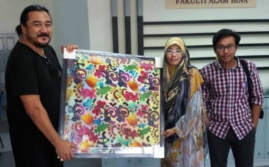 Simplicio Micheal Luis Asis Herrera or known as M (left) receiving the Batik gift from UTM Batik Instructor, Arfinah Ariff (right) after the ceremony.