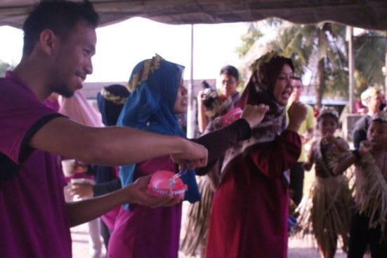 Showing the most effective way in brushing teeth to Orang Asli community at Perling Orang Ali settlement.