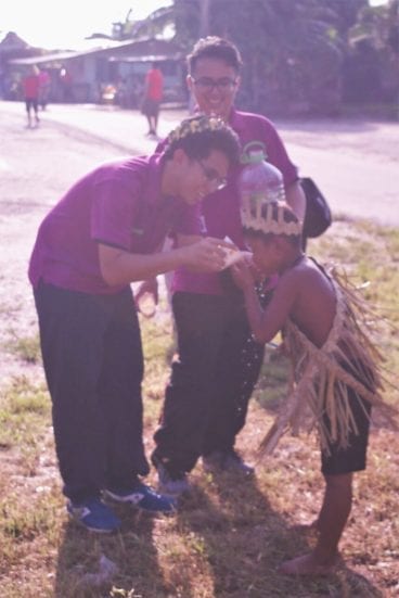 UTMBIOSS member showing Orang Asli kids to drink healthy clean water