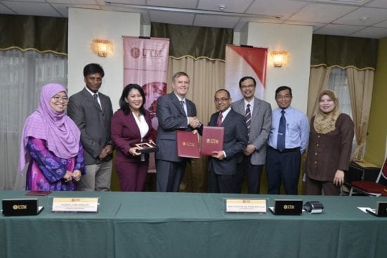 Prof. Wahid (fourth right) exchanging the MoA document with Mr. Stephen James (fourth left) after the Memorandum of Agreement between UTM-Applied Energy Sdn. Bhd. signing ceremony held at Dewan Sultan Iskandar, UTM Johor Bahru. 