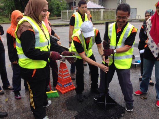 Prof. Mohamad dan Prof. Madya Dr kamaruddin Ahmad sedang memampatkan asfalt sambil diperhatikan oleh Dr Norhidayah.