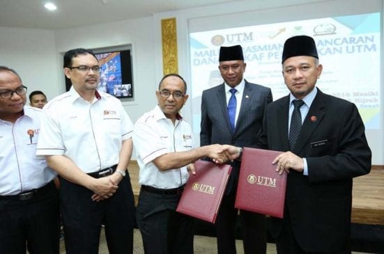 Prof. Wahid (third left) and Mohd Rofiki exchanging the MoA of establishing the UTM Education waqf at the Banquet Hall.