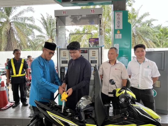 ADUN Kota Iskandar mengisi motosikal mahasiswa UTM dengan minyak RON95
