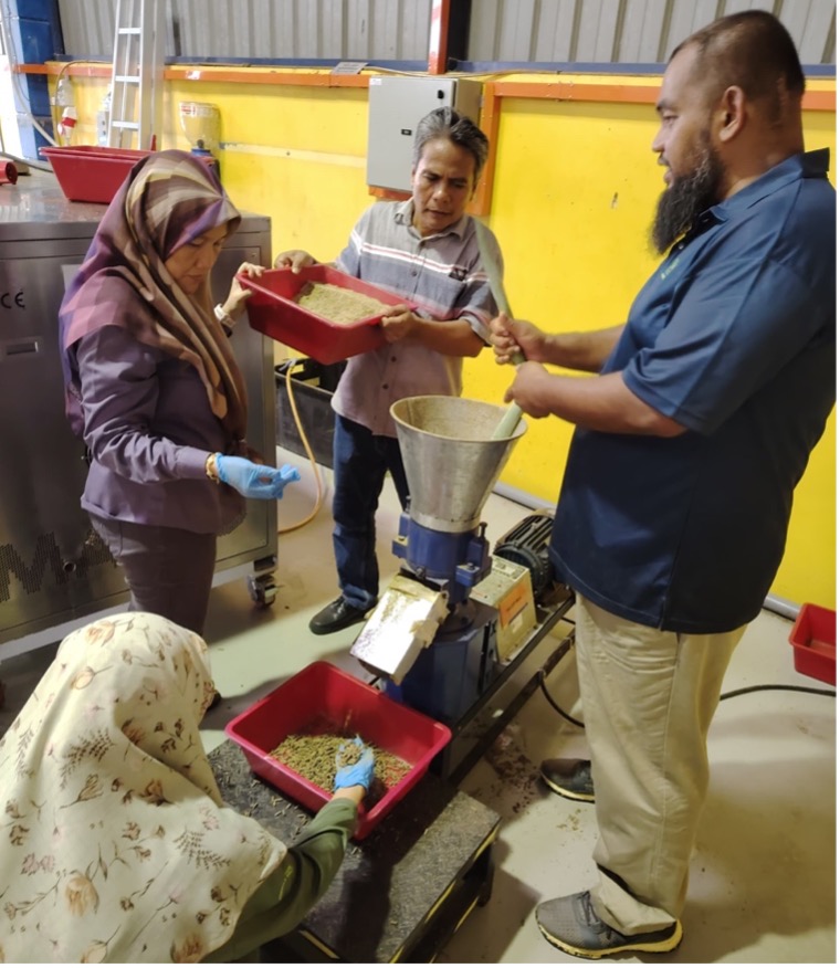 Peserta sedang menghasilkan pelet dengan menggunakan mesin pelet